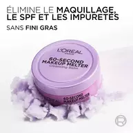 Le pot de baume demaquillant violet est pose sur une texture vaporeuse et violette rappelant un nuage de produit. Le texte en haut a gauche indique : « ELIMINE LE MAQUILLAGE, LE SPF ET LES IMPURETES SANS FINI GRAS ».