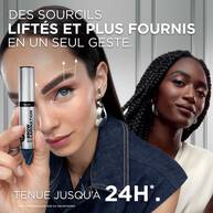 Portrait de deux femmes (l'une a la peau claire, l'autre a la peau foncee) affichant des sourcils etoffes et liftes de maniere naturelle. Des fleches blanches sur le visage de la femme au premier plan illustrent le mouvement de rehaussement vers le haut. Le texte indique : « DES SOURCILS LIFTES ET PLUS FOURNIS EN UN SEUL GESTE. TENUE JUSQU'A 24H.* »