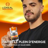 Romain Ntamack tient le pot de L'Oreal Men Expert Hydra Energetic Soin Hydratant Anti-Fatigue 24H dans sa main droite. Il regarde directement l'objectif avec un leger sourire. En bas de l'image, le texte "FAITES LE PLEIN D'ENERGIE" est ecrit en grandes lettres blanches, suivi de "PARCE QUE VOUS LE VALEZ BIEN." sur un fond orange.