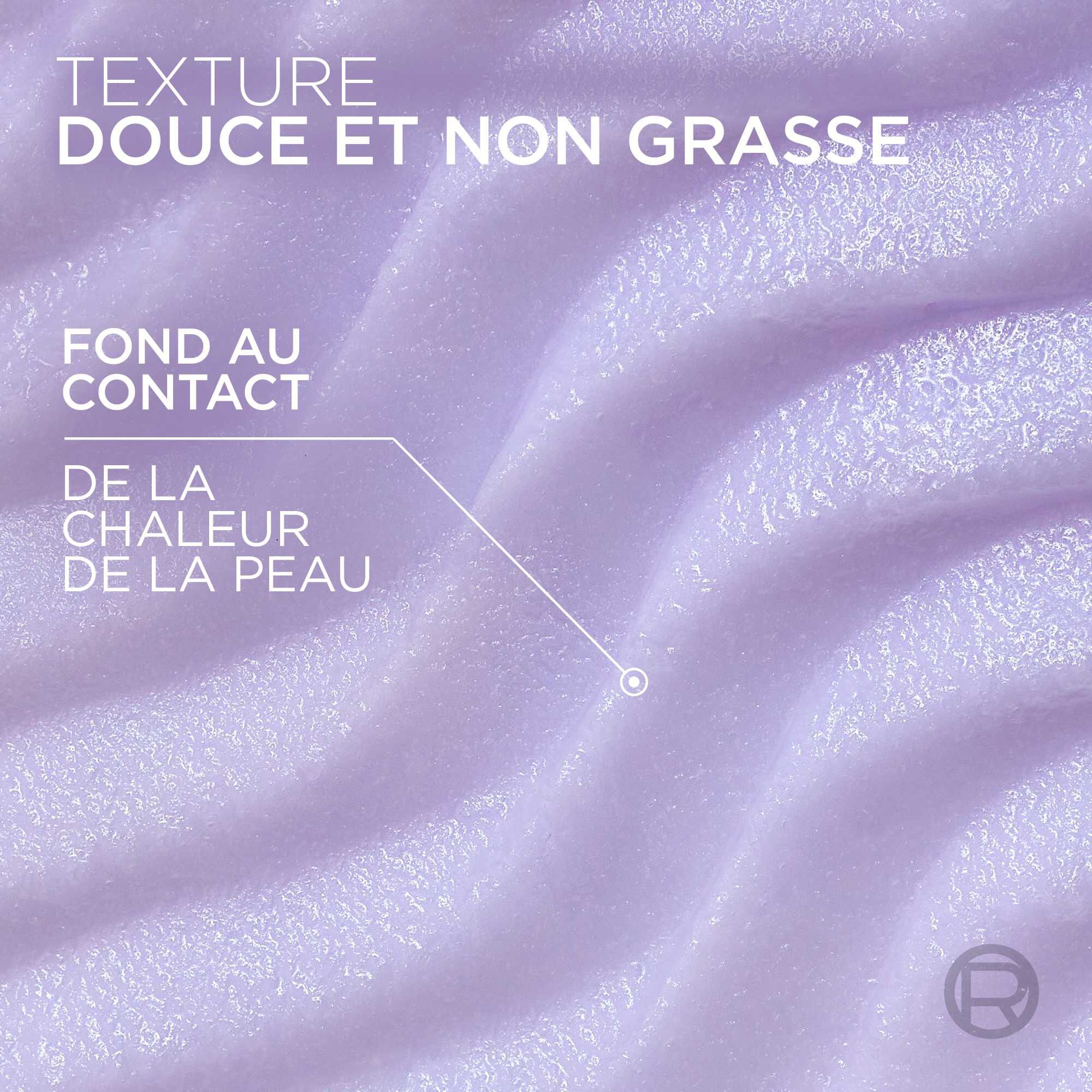 Gros plan texture sur le baume de couleur violette, montrant des vagues cremeuses et douces. Le texte superpose indique : « TEXTURE DOUCE ET NON GRASSE » et une fleche precise « FOND AU CONTACT DE LA CHALEUR DE LA PEAU ».