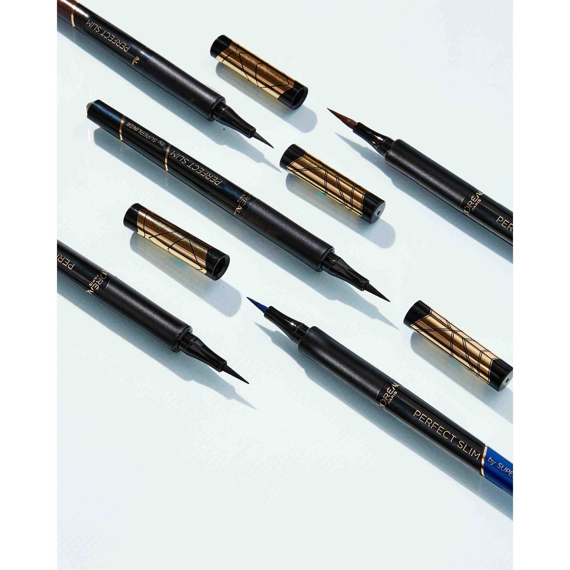 Mise en scene a plat de plusieurs eye-liners Super Liner Perfect Slim avec leurs capuchons ouverts et fermes sur fond clair.​