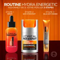 Presentation de la "Routine Hydra Energetic" en 3 etapes. A gauche, un flacon orange et gris de "Serum" Hydra Energetic 10% Vitamine C Pure. Au centre, le pot de "Soin Hydratant" Hydra Energetic Anti-Fatigue 24H (le produit principal). A droite, une "Bille Anti-Cernes" Hydra Energetic Eyes/Yeux. Les trois produits sont alignes sur un fond orange degrade.