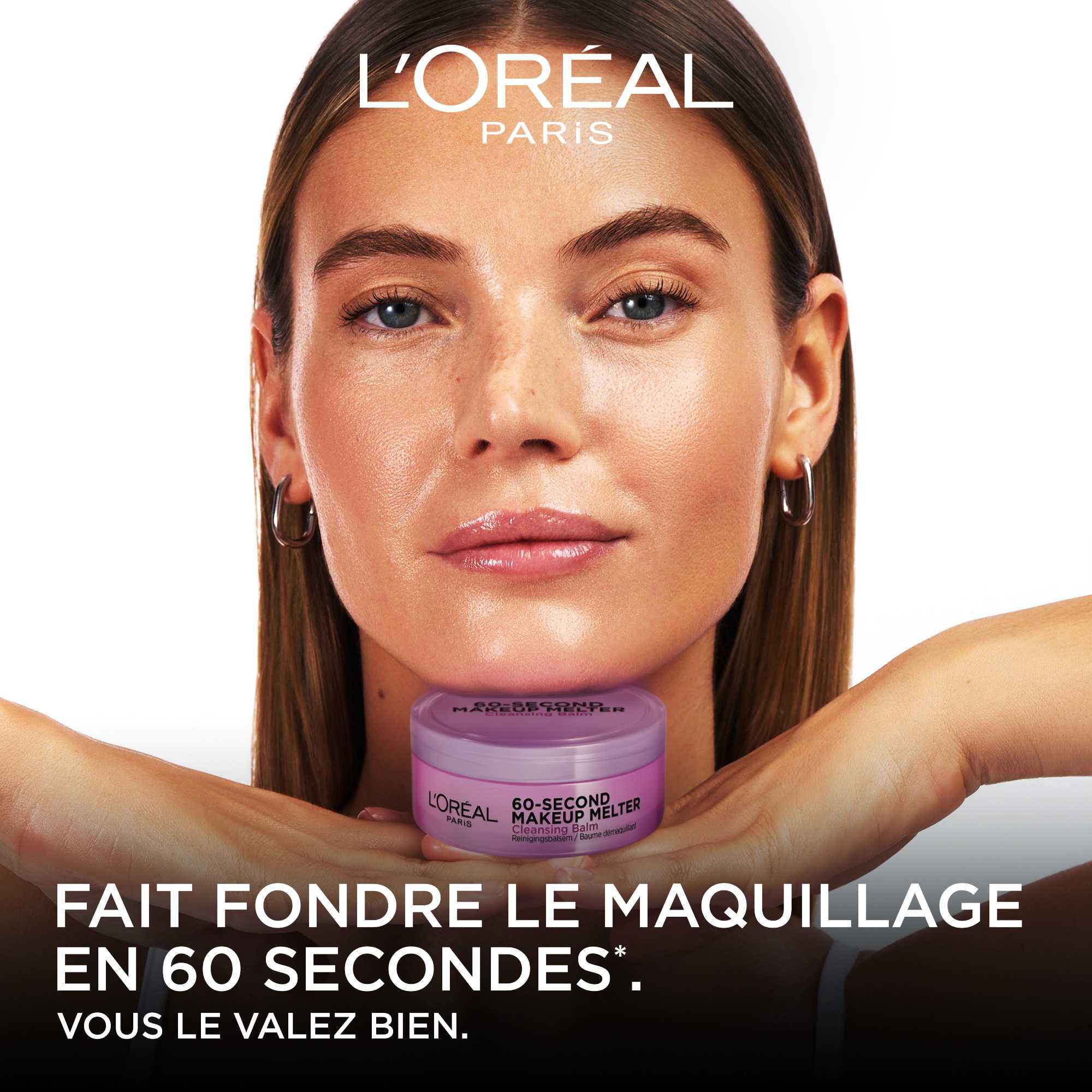 Une mannequin au teint eclatant pose avec le pot de baume demaquillant violet pose sous son menton. En bas de l'image, sur fond noir, est ecrit en lettres capitales blanches : « FAIT FONDRE LE MAQUILLAGE EN 60 SECONDES*. VOUS LE VALEZ BIEN. » sous le logo blanc L'Oreal Paris.
