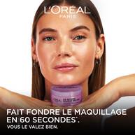 Une mannequin au teint eclatant pose avec le pot de baume demaquillant violet pose sous son menton. En bas de l'image, sur fond noir, est ecrit en lettres capitales blanches : « FAIT FONDRE LE MAQUILLAGE EN 60 SECONDES*. VOUS LE VALEZ BIEN. » sous le logo blanc L'Oreal Paris.