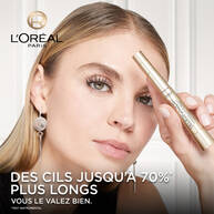 Femme tenant un mascara L'Oreal Paris Telescopic pres de son visage, avec le logo L'Oreal Paris et la promesse de cils plus longs en texte.