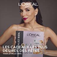 Eva Longoria souriante tenant un coffret cadeau L'Oreal Paris Revitalift Filler avec le texte "Les cadeaux les plus desires des fetes Vous le valez bien"​