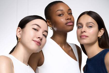 Trois femmes aux carnations variees arborant un maquillage naturel et lumineux sur fond blanc.